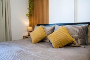 a bed with two yellow pillows on top of it at ILIRIA Apartment in Durrës