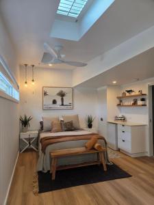a bedroom with a bed with a bench in it at Seaclusion at Byron in Byron Bay