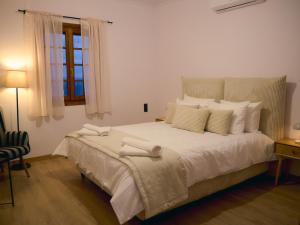 a bedroom with a large white bed with a window at Marilion Villa in Ioannina