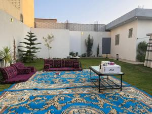 a rug on the ground in a yard with a table at Garden land in Khamis Mushayt