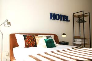 um quarto com uma cama com uma placa de hotel na parede em Oporto Chic&Cozy - Batalha em Porto