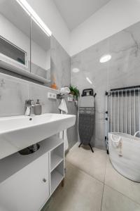 a white bathroom with a sink and a shower at Loftly Modersohnstr nähe East Side Gallery nähe Uber Arena in Berlin +62 photos
