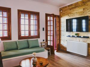a living room with a green couch and a tv at Marilion Villa in Ioannina