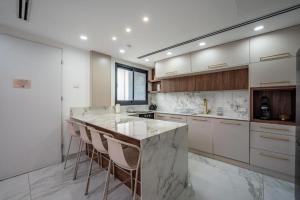 a large kitchen with a marble counter and stools at צוקים אילת in Eilat