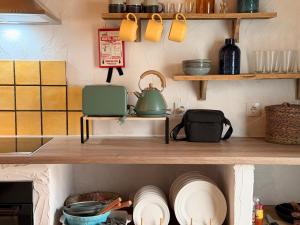 a kitchen with wooden shelves with plates and pots and pans at Encanto do frade in Carrapatelo