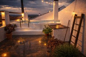 a white house with a sink and stairs at night at Encanto do frade in Carrapatelo
