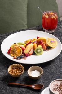 a plate of fruit on a table with a drink at Origen 438 Luxury Boutique Hotel in Guadalajara