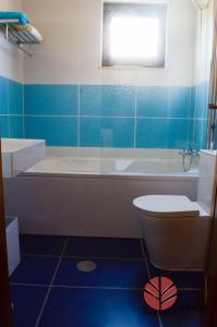 a bathroom with a tub and a toilet and a sink at Brisa Village in São Tomé