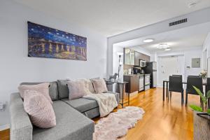 a living room with a gray couch and a kitchen at Stylish 2BR Downtown Sanctuary - Free Parking in Toronto