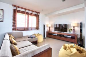 a living room with a couch and a tv at Baan Apsara - Stunning Sea View 3 Bed Pool Villa in Choeng Mon Beach