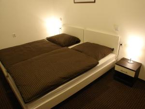 1 dormitorio con 1 cama con 2 almohadas en Rooms Levicki, en Slavonski Brod