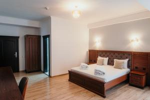 a bedroom with a bed with white sheets and a table at Hotel Restaurant Elite in Drobeta-Turnu Severin