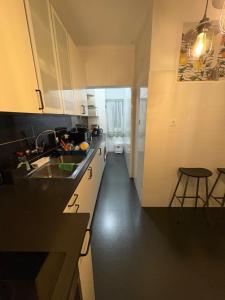 a kitchen with white cabinets and a black floor at Quarto Espaçoso in Amora +10 photos