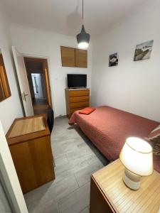 a bedroom with a bed and a desk with a lamp at Quarto Espaçoso in Amora