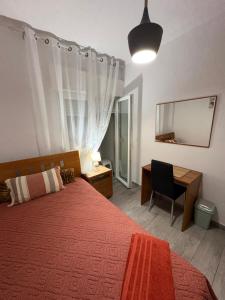 a bedroom with a bed and a desk and a mirror at Quarto Espaçoso in Amora