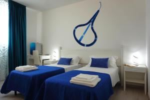 two beds in a room with blue and white at Sa Trunfa Rooms in Tortolì