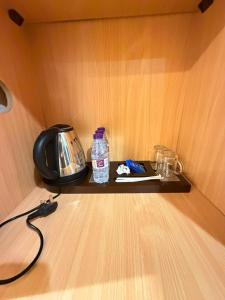 a shelf with a bottle of water and a telephone at Etqan Al Mashair Two in Mecca