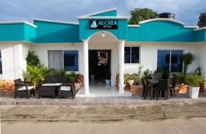 a blue and white building with tables and chairs at Hotel ALCALA in Mingueo