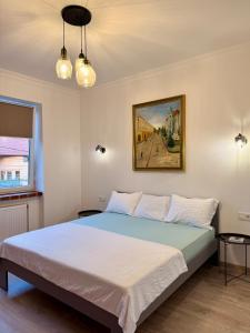 a bedroom with a bed with a painting on the wall at Федорцьо in Mukacheve