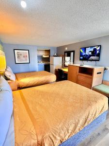 a hotel room with two beds and a desk at Rodeway Inn Findlay University Area in Findlay