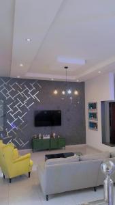 a living room with a couch and a tv at chez Louise in Saly Portudal