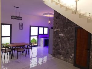 a dining room with a table and a stone wall at chez Louise in Saly Portudal
