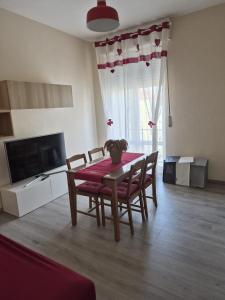 a living room with a table and chairs and a television at Ca d'la Mondina Apartment in Vercelli