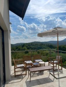 a patio with a table and chairs and an umbrella at House Joie in Blaguša
