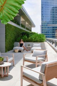a woman is sitting on a ledge on a building at Brickell Arch, a Luxury Collection Hotel, Miami in Miami