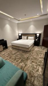 a bedroom with a large white bed and a carpet at شقق تبيان سويت للشقق المخدومة الفرع الاول in Ar Ruwanah