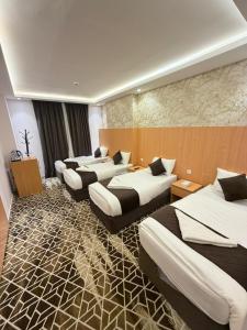 a hotel room with four beds in a room at Etqan Al Mashair Two in Mecca