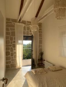 a bedroom with a bed in a room with a window at House Joie in Blaguša