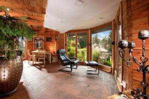 a living room with chairs and a table and windows at Mountain Chalet Podgorje with Pool - Happy Rentals in Slovenj Gradec