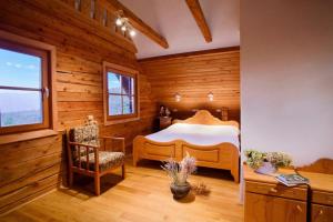 a bedroom with a bed in a room with wooden walls at Mountain Chalet Podgorje with Pool - Happy Rentals in Slovenj Gradec