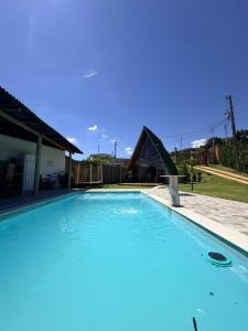 a large swimming pool with a playground in the background at Chalé Bruma in Pouso Alegre