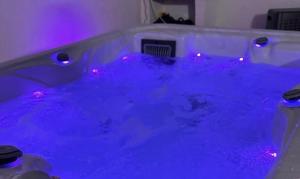 a blue bathtub with purple lights in a room at Qatar Apartment in Cosenza +31 photos