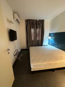 a bedroom with a bed and a television in it at Qatar Apartment in Cosenza