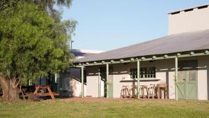 a white building with a picnic table and a tree at Casa Cosmos in Colonia Ayui