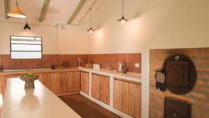 a kitchen with wooden cabinets and a tv on the wall at Casa Cosmos in Colonia Ayui