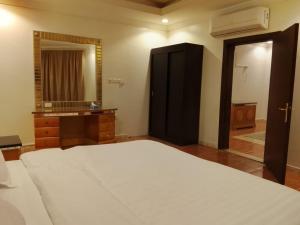 a bedroom with a large bed and a large mirror at شقق تبيان سويت للشقق المخدومة الفرع الاول in Ar Ruwanah