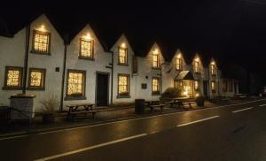 a row of buildings with lit up windows at night at The Inn at Strathyre in Strathyre