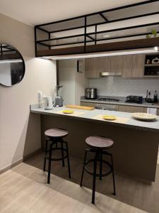 a kitchen with two bar stools at a counter at Miraflores Loft Piscina in Lima