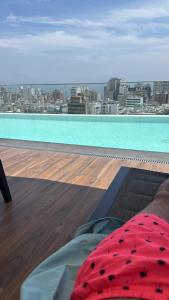 a person laying on a bed on top of a roof at Miraflores Loft Piscina in Lima