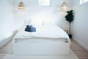 a white bedroom with a white bed and two lights at California Suite in Fort Saint John