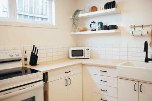a kitchen with a sink and a microwave at California Suite in Fort Saint John