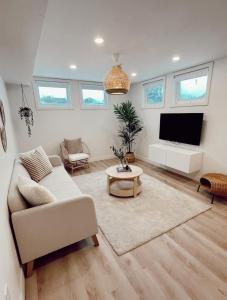 a living room with a couch and a flat screen tv at California Suite in Fort Saint John