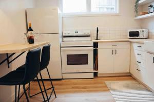 a kitchen with white appliances and a table and chairs at California Suite in Fort Saint John +31 photos