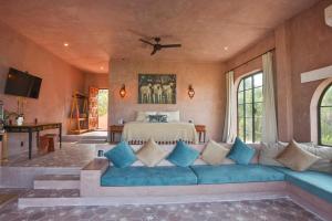 a living room with a blue couch and a bed at Nomada Wellness Hotel in Sayulita