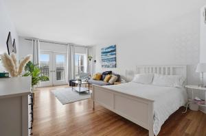 a white bedroom with a bed and a couch at Condo St-Roch in Quebec City