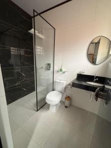 a bathroom with a toilet and a shower and a sink at The Riverside in Novo Acordo +9 photos